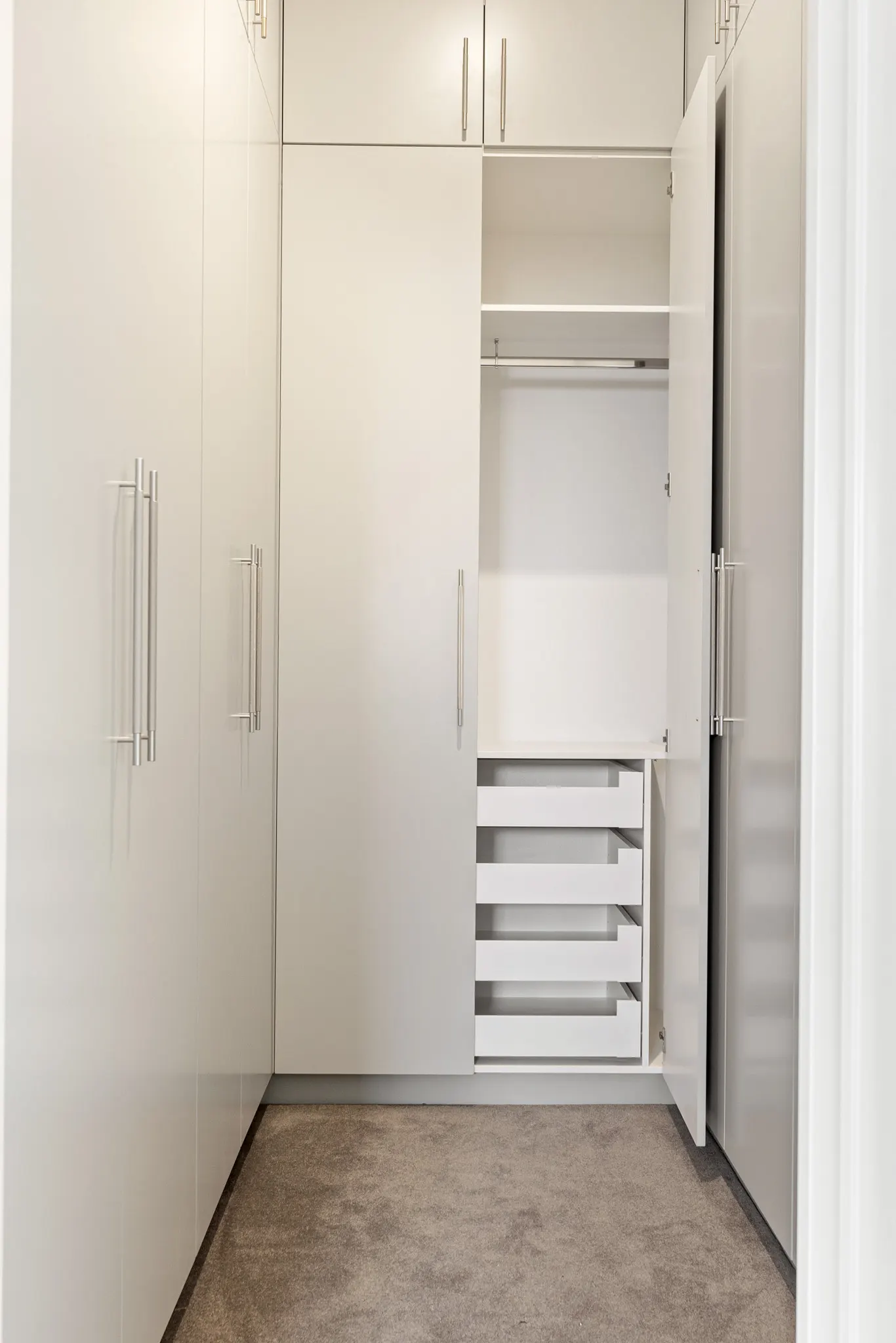 Walk-in robe with white joinery, hanging rail and internal drawers