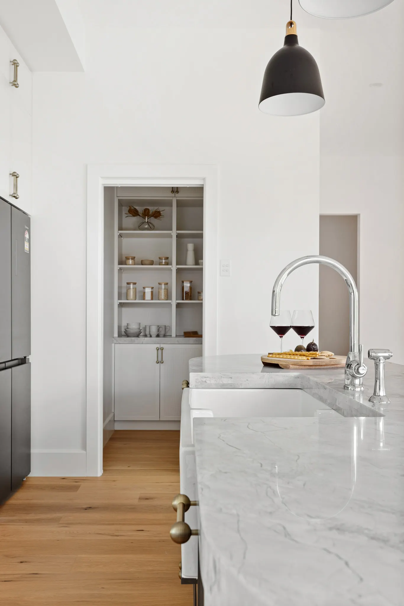 Marble island with gooseneck tapware, looking through to the butler&rsquo;s pantry