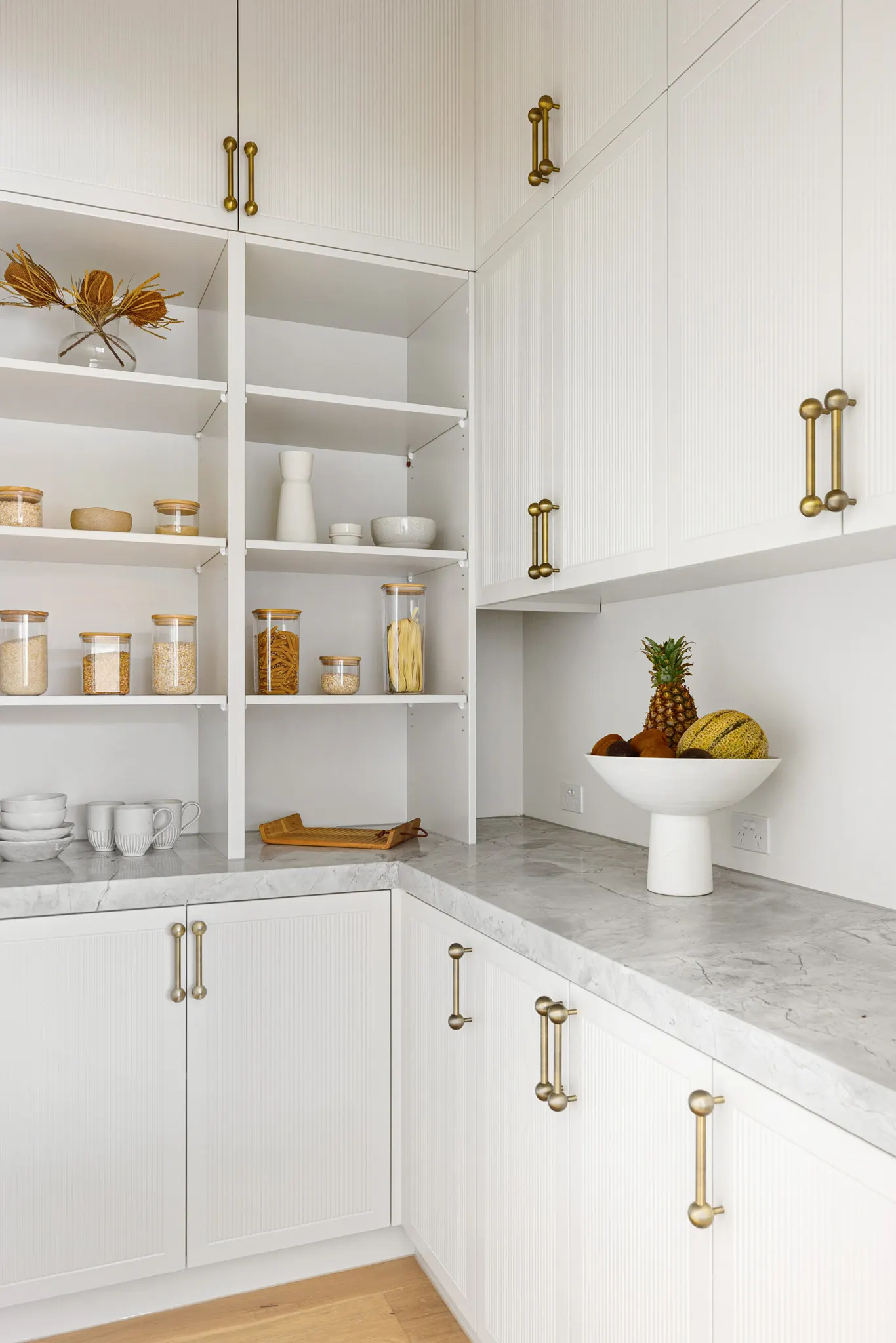 Wraparound marble benchtop in the butler&rsquo;s pantry with white fluted joinery