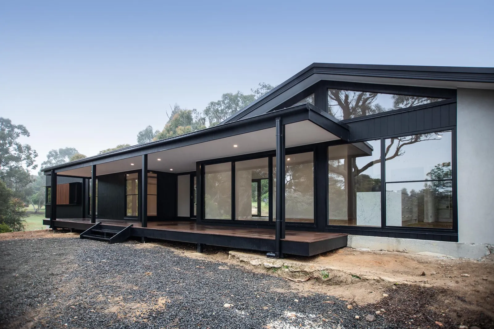 Veranda running the length of the glazed elevation, with a timber deck and black posts