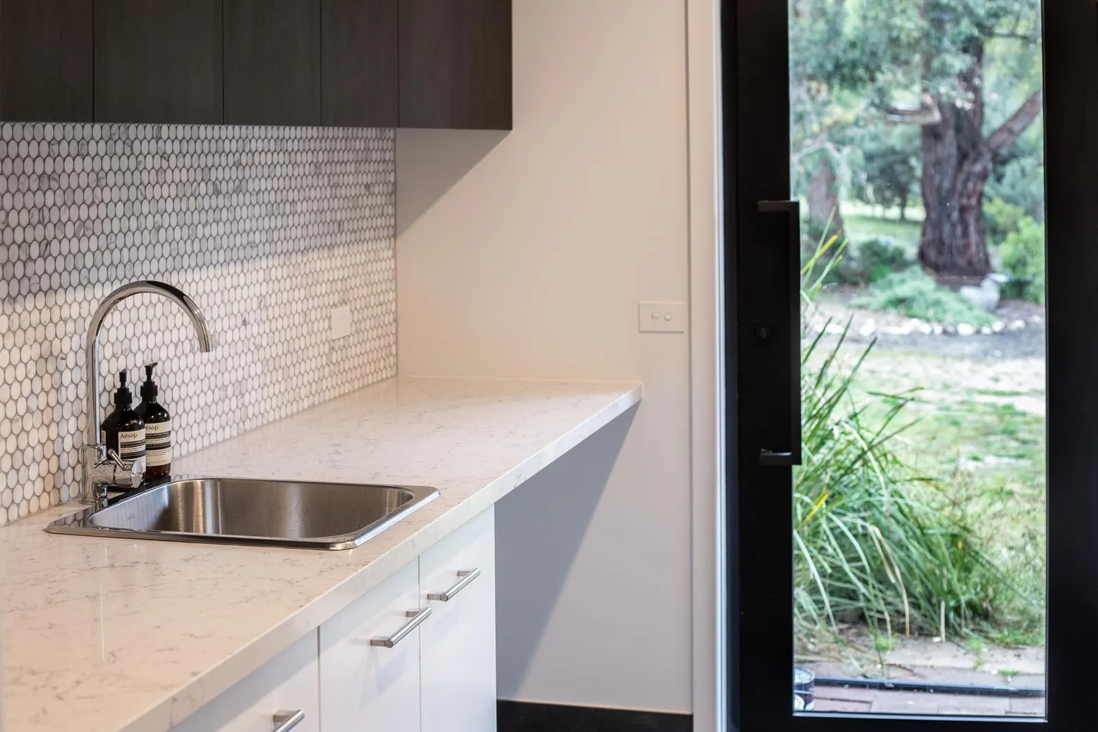 Butler&rsquo;s pantry with a stainless sink, gooseneck tapware and a glazed garden door
