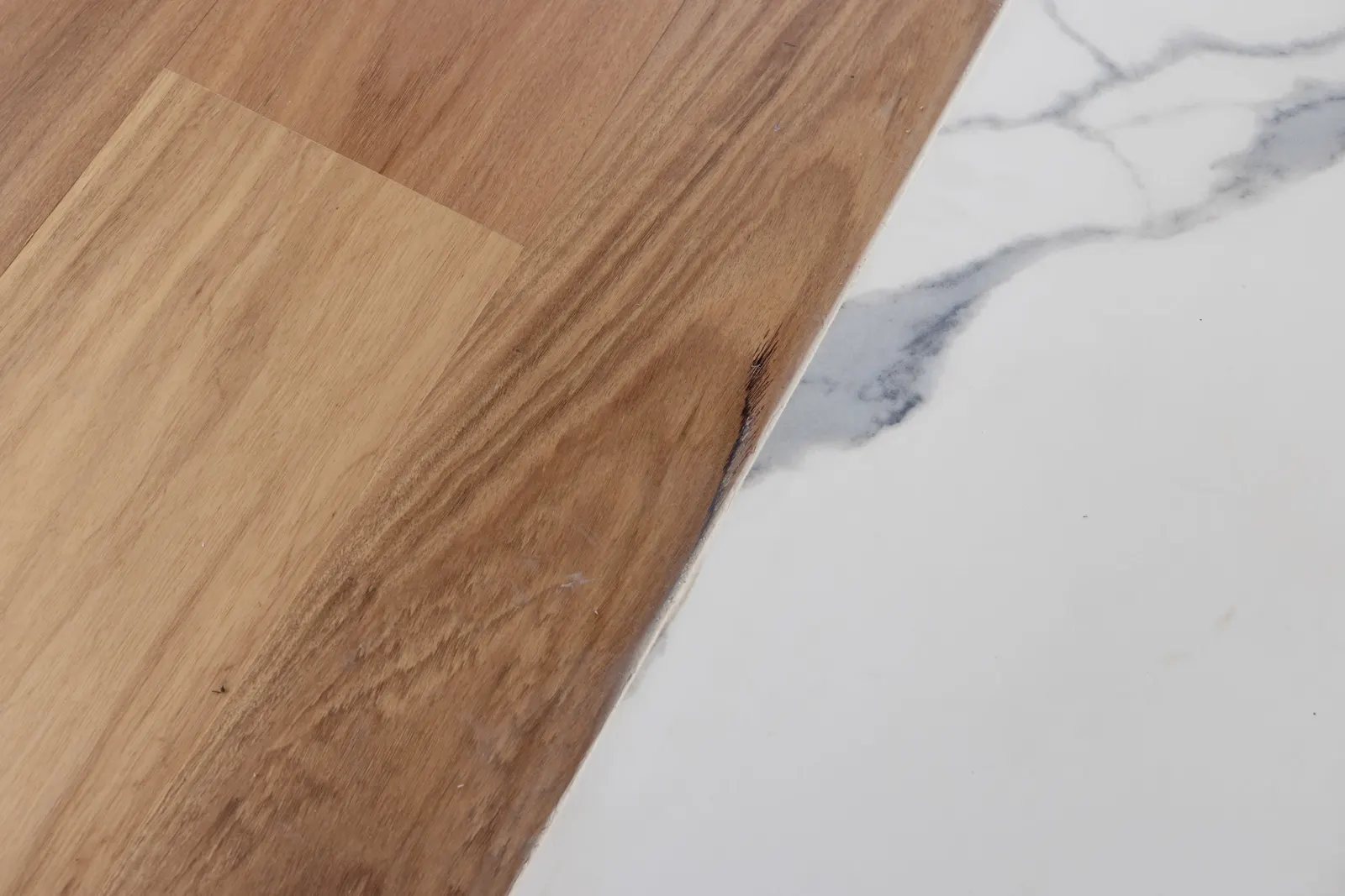 Detail where oak floorboards meet the white veined marble hearth