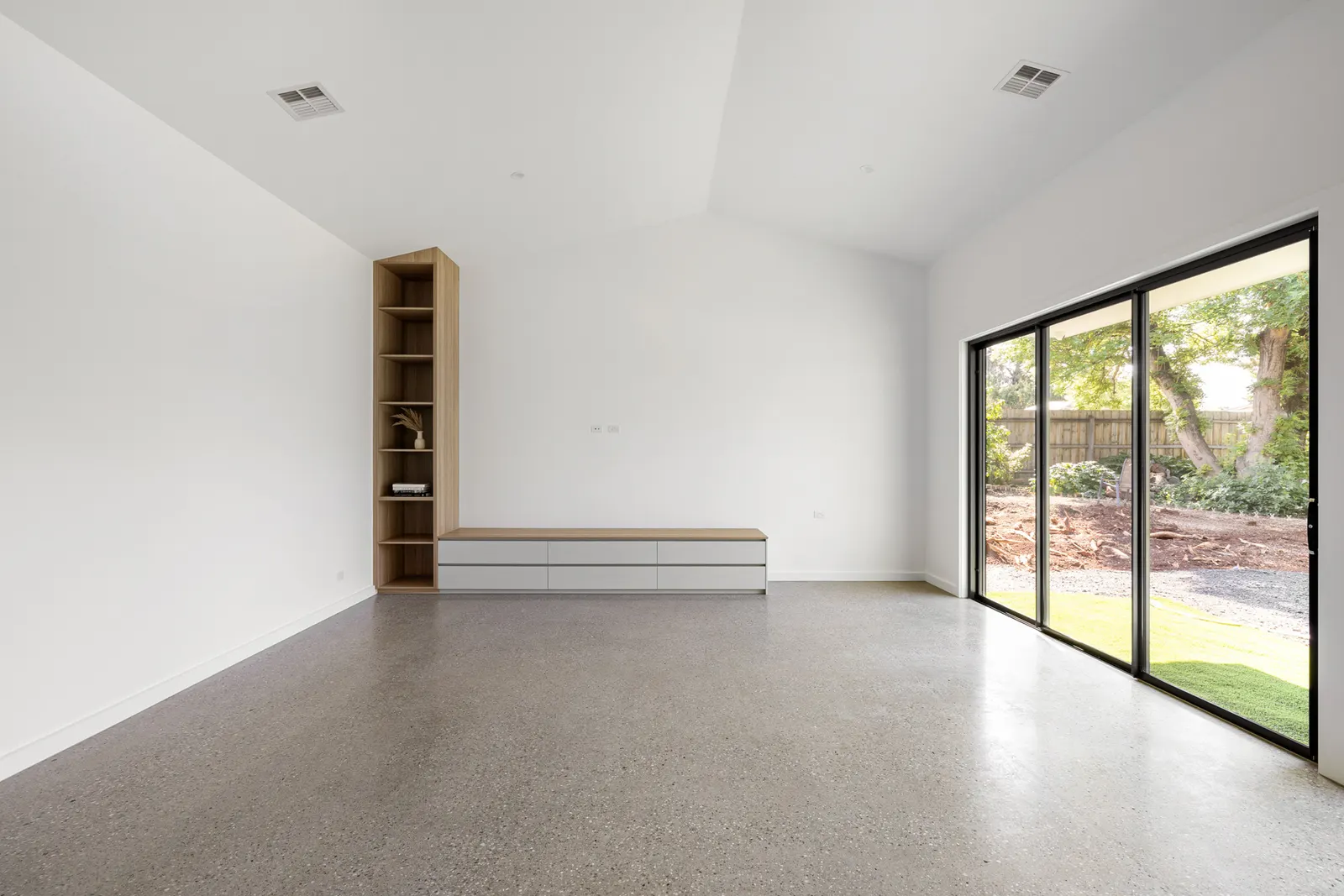Living room with a built-in timber bench and shelving niche beside sliding doors