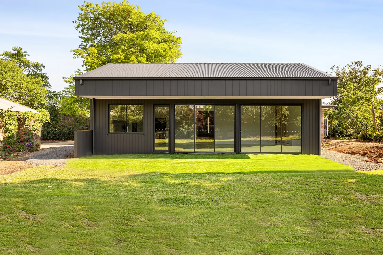 The Manor&rsquo;s dark pavilion in the Macedon Ranges, wide glazing facing the lawn