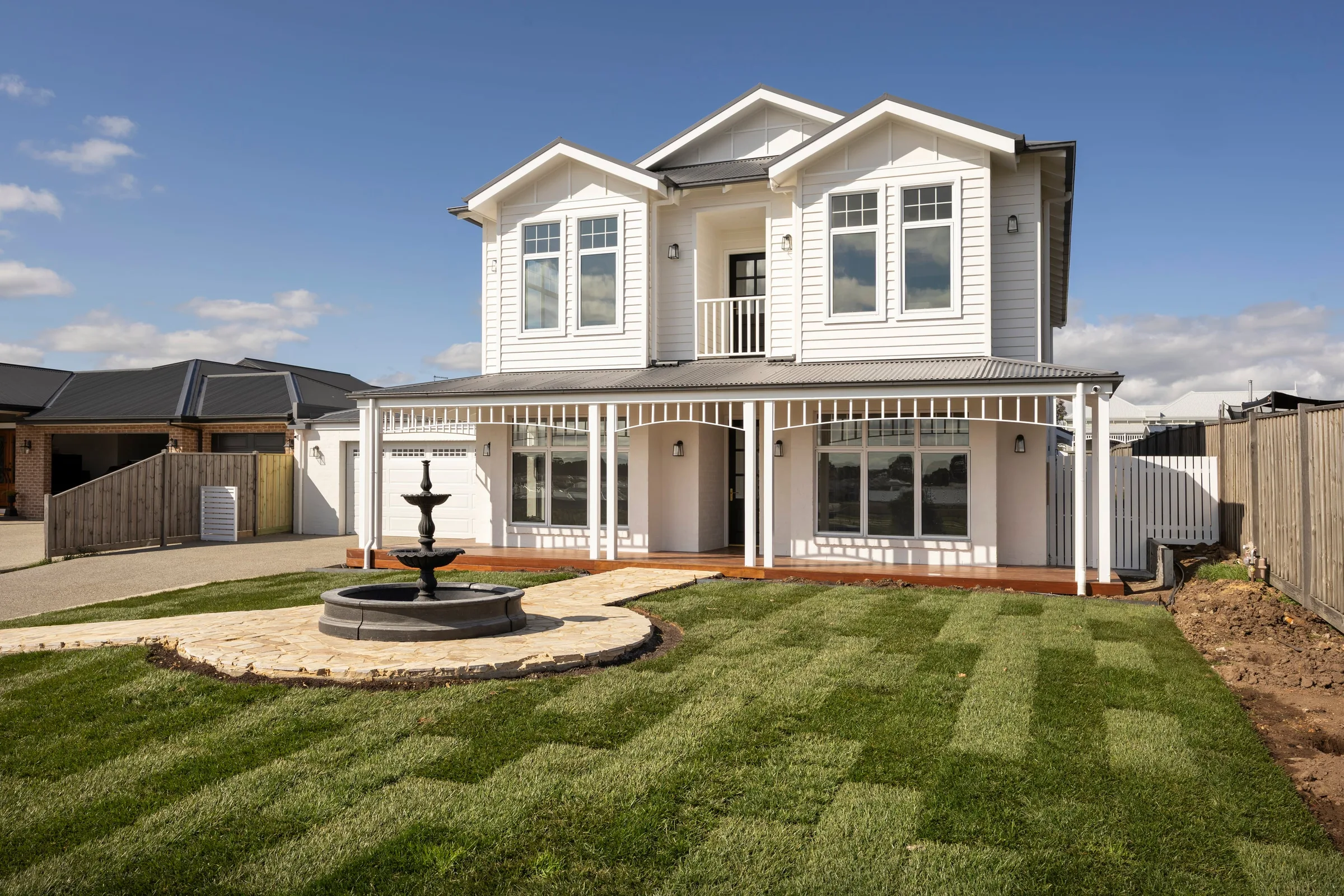 Three-quarter view across the new lawn to the fountain and verandah