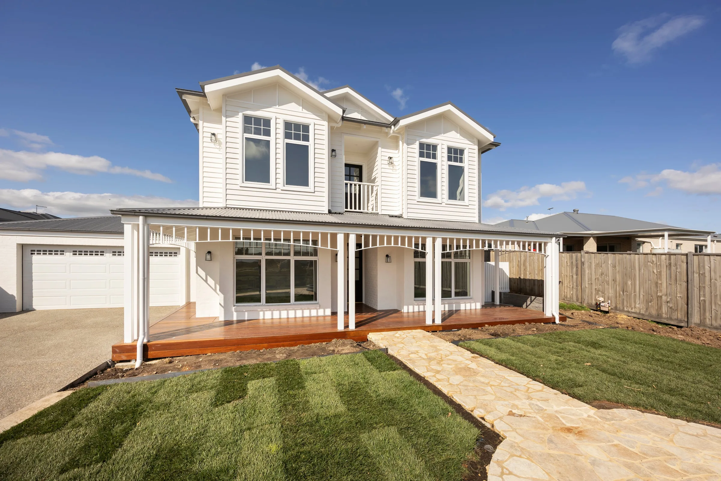 Timber verandah deck and a crazy-paved path in front of the living room windows