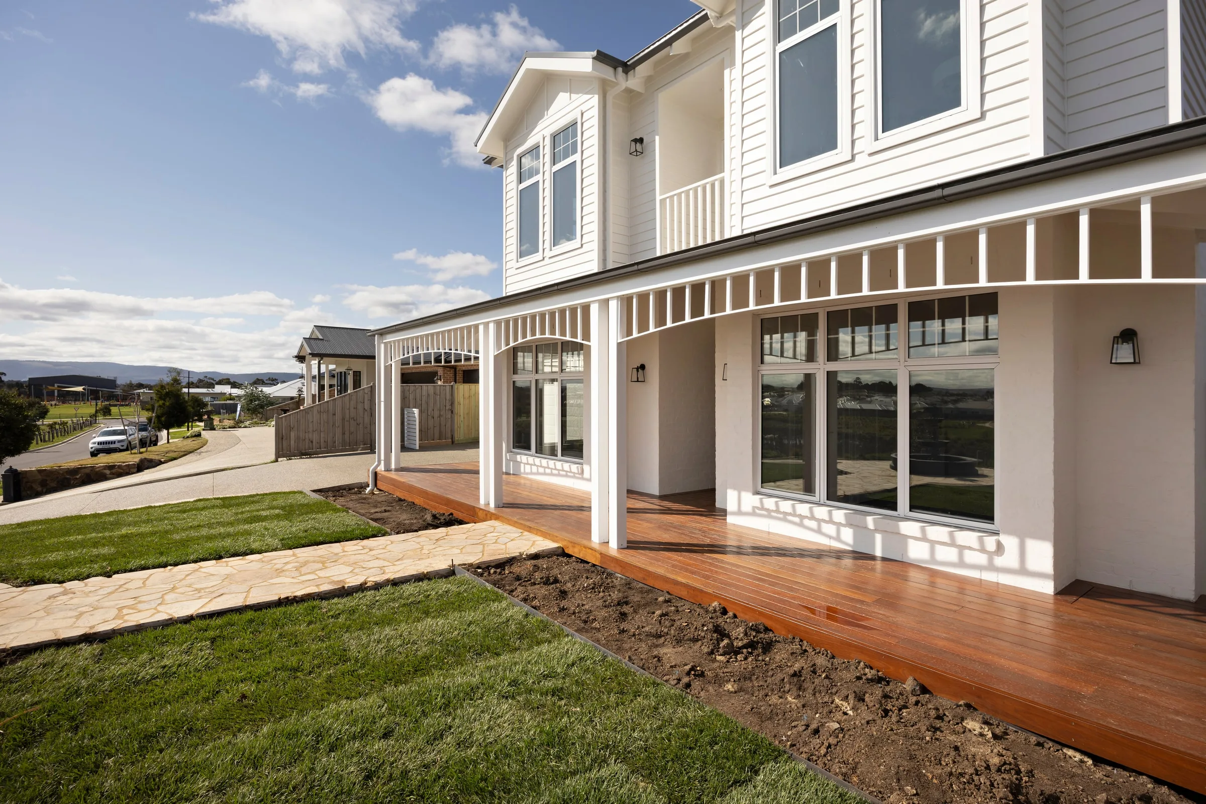 Verandah wrapping the corner of the house above the new lawn