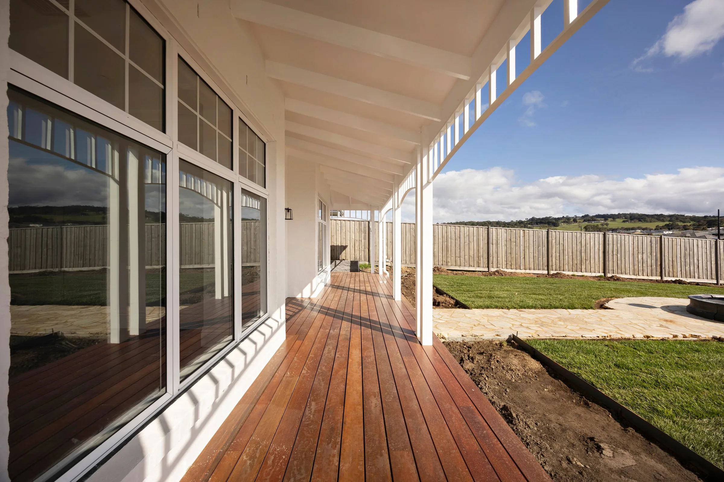 Looking along the verandah, timber boards beside full-height windows