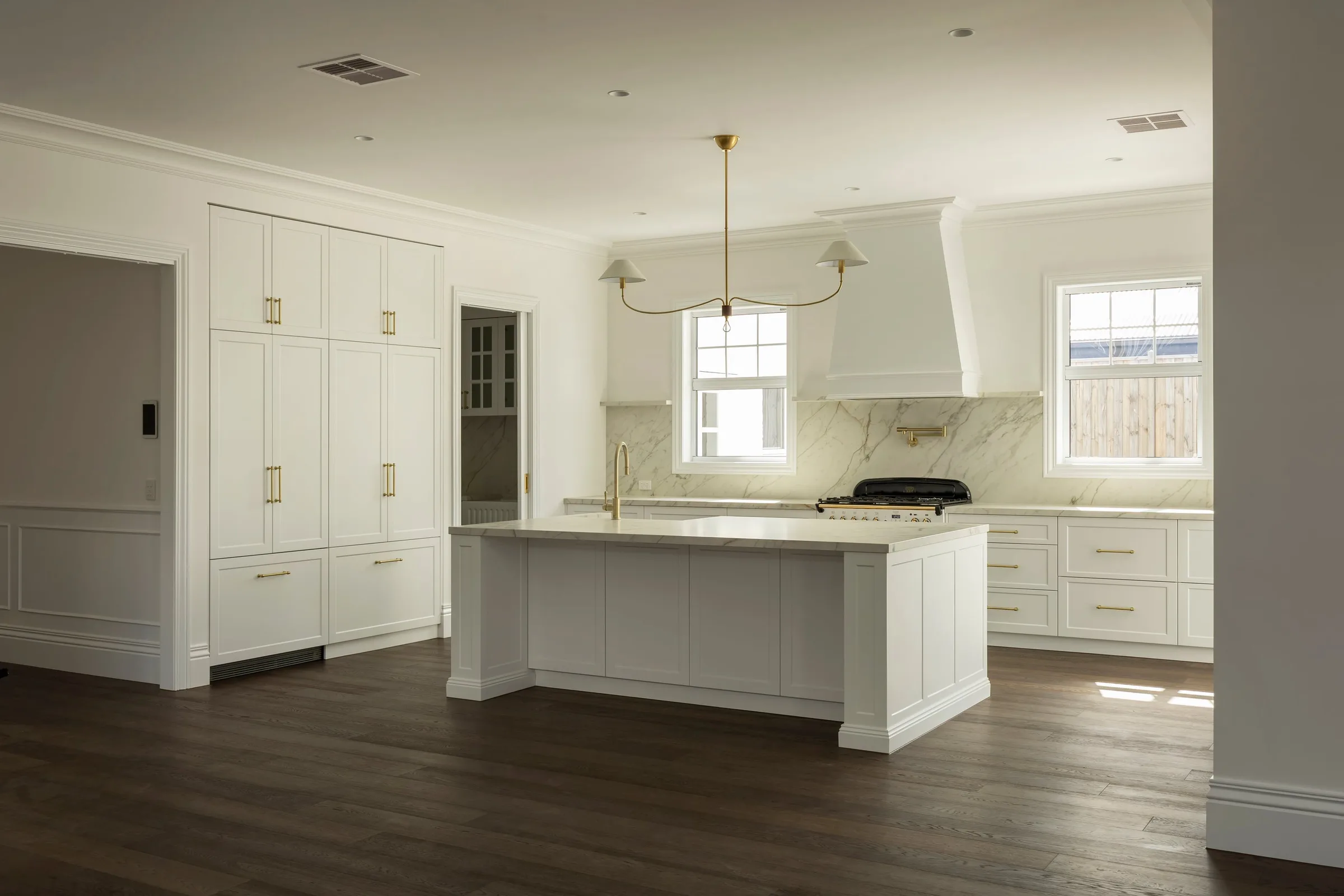 The kitchen from the dining end, full-height joinery beside the island