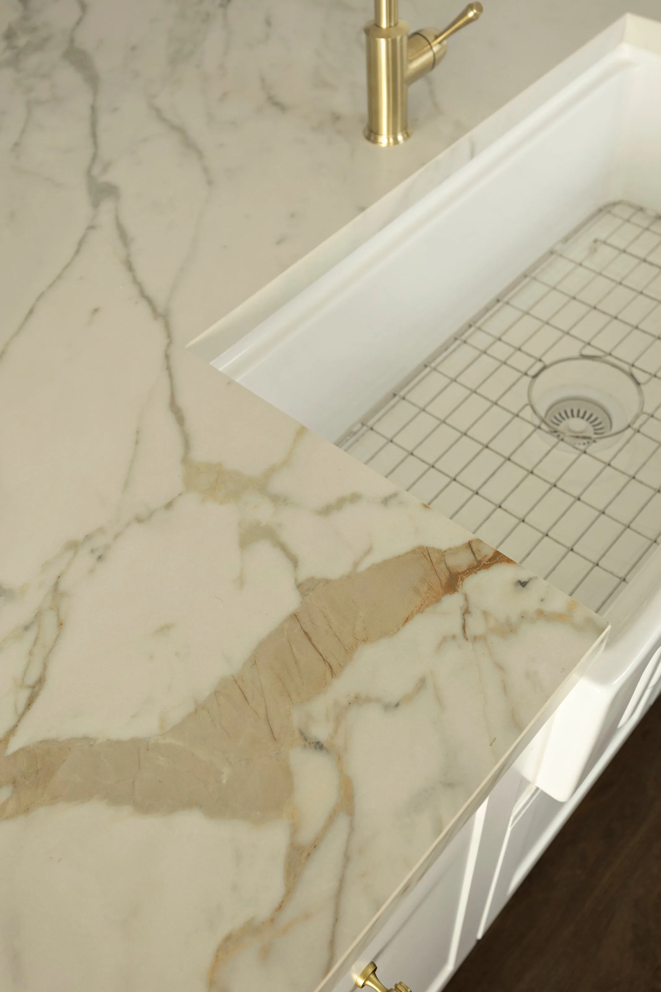 Gold-veined benchtop meeting the farmhouse sink, seen from above