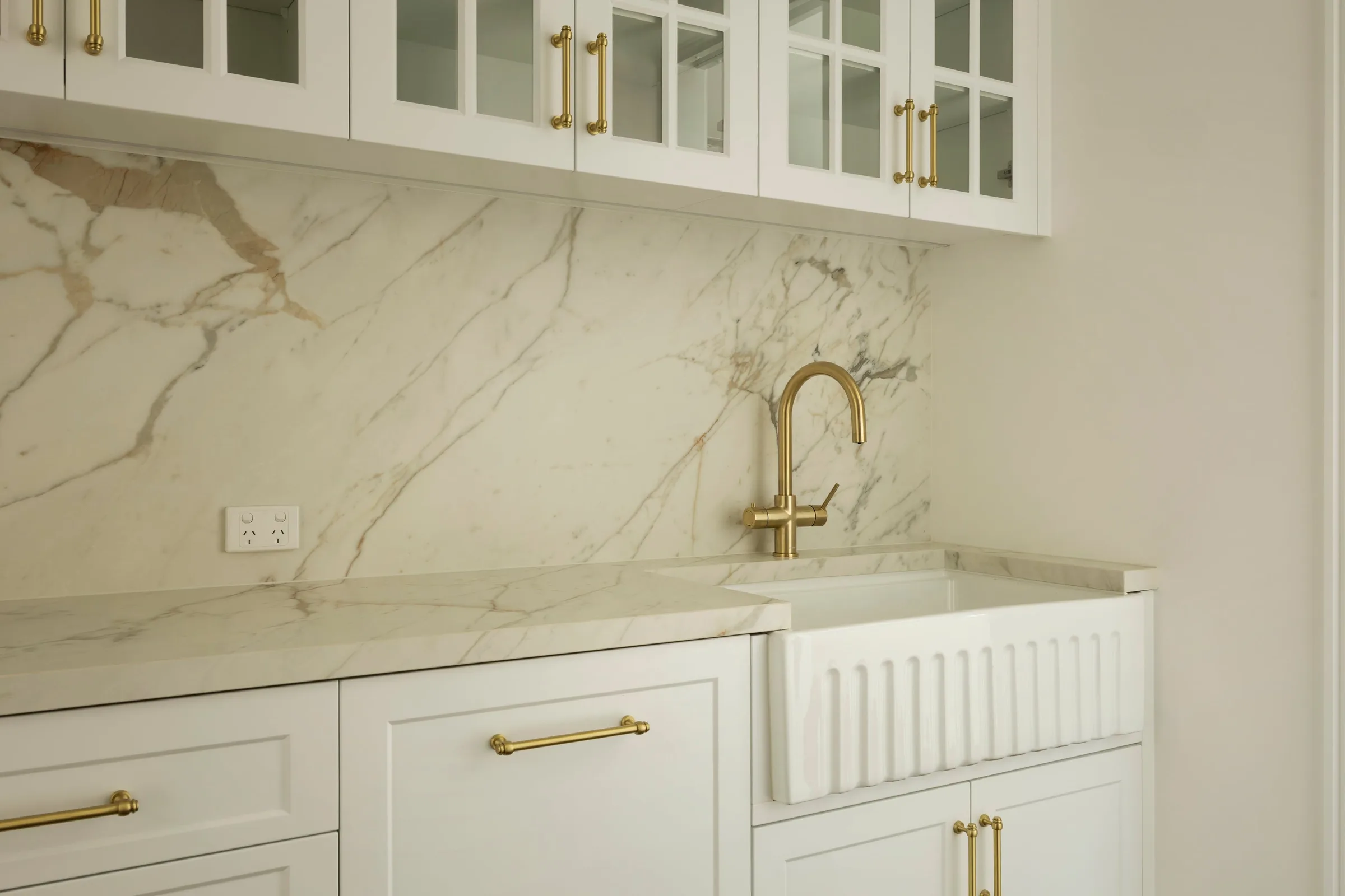 Brass tap against the marble-look splashback in the butler&rsquo;s pantry