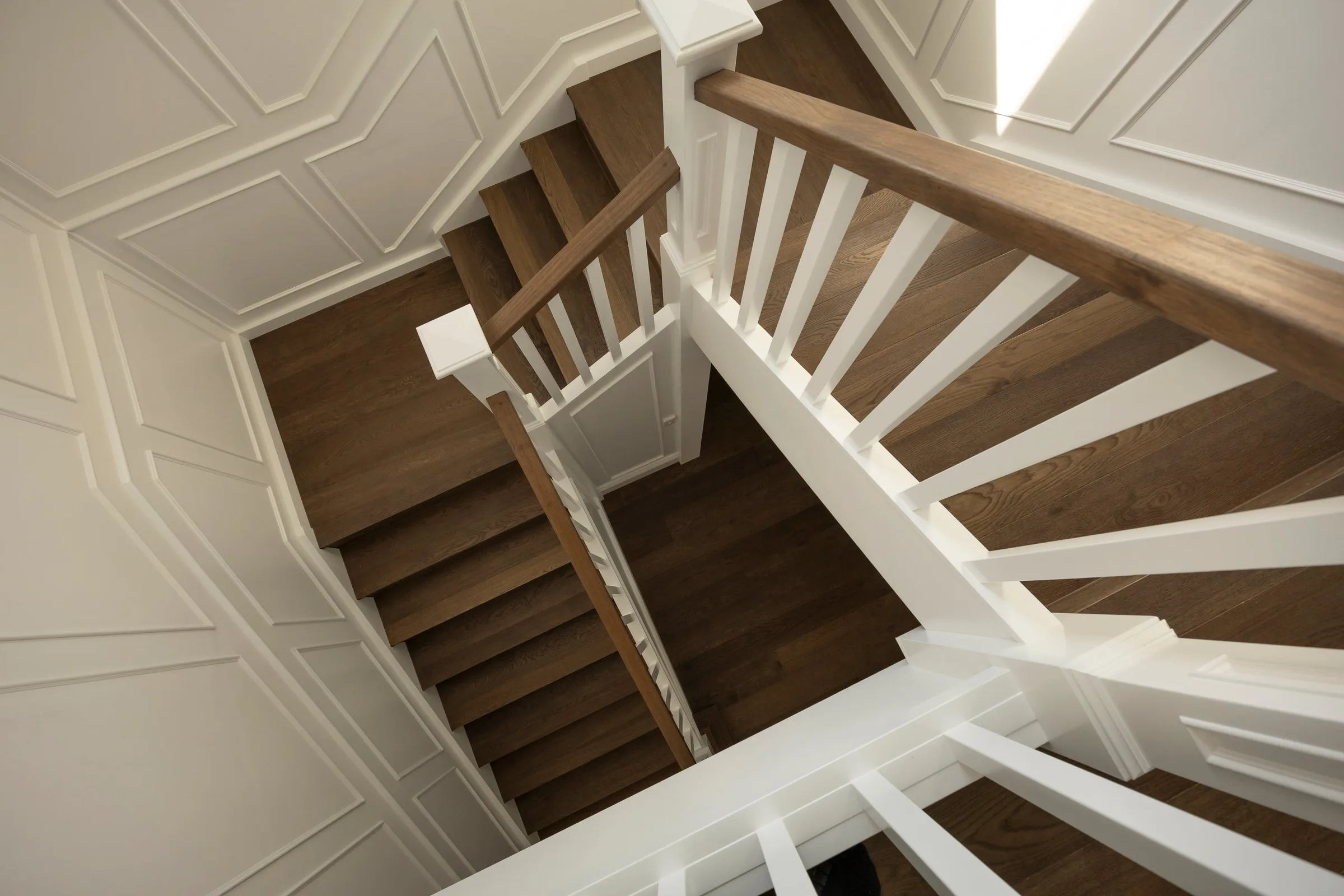 Looking down the stairwell, oak treads and white balusters
