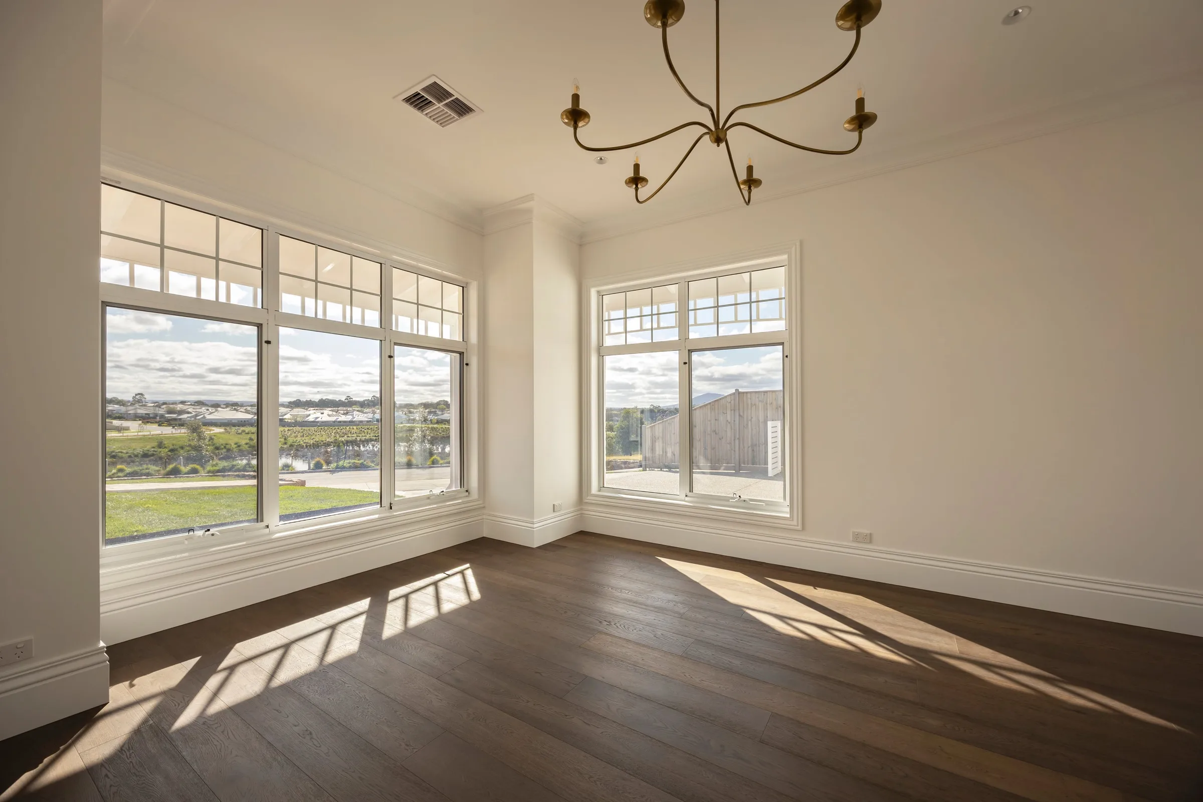 Corner room with windows on two sides and a wrought-iron chandelier