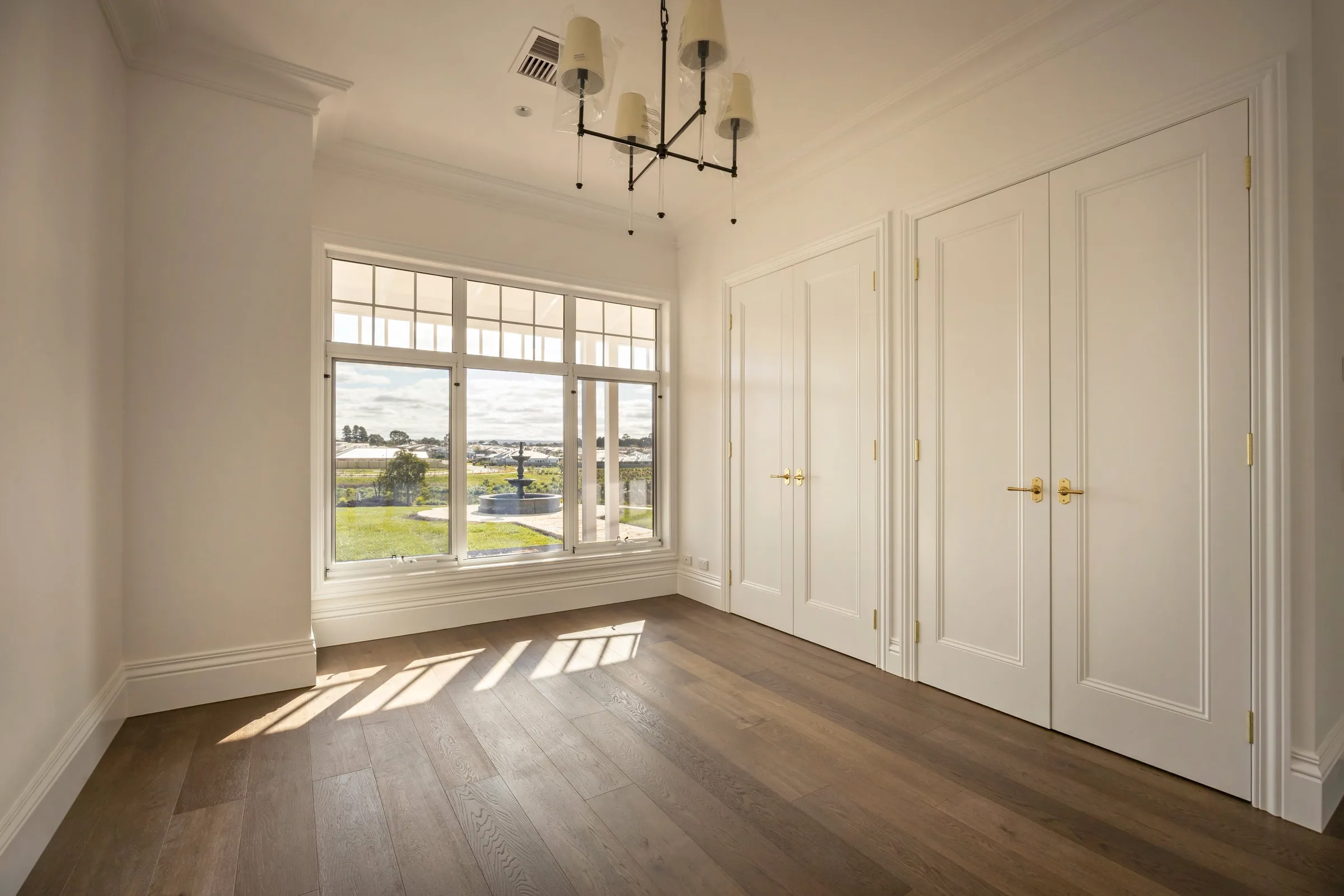 Bedroom with two sets of panelled robe doors and a black chandelier