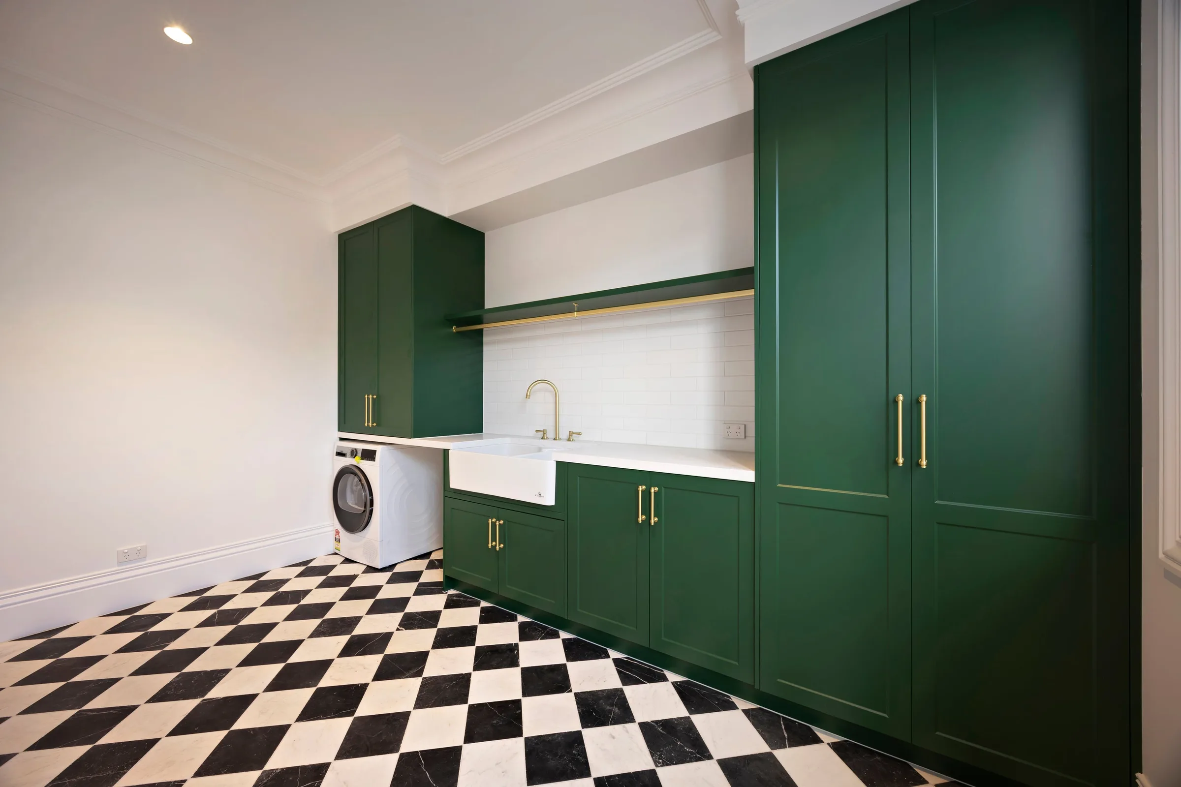 Green shaker laundry over a black and white checkerboard floor