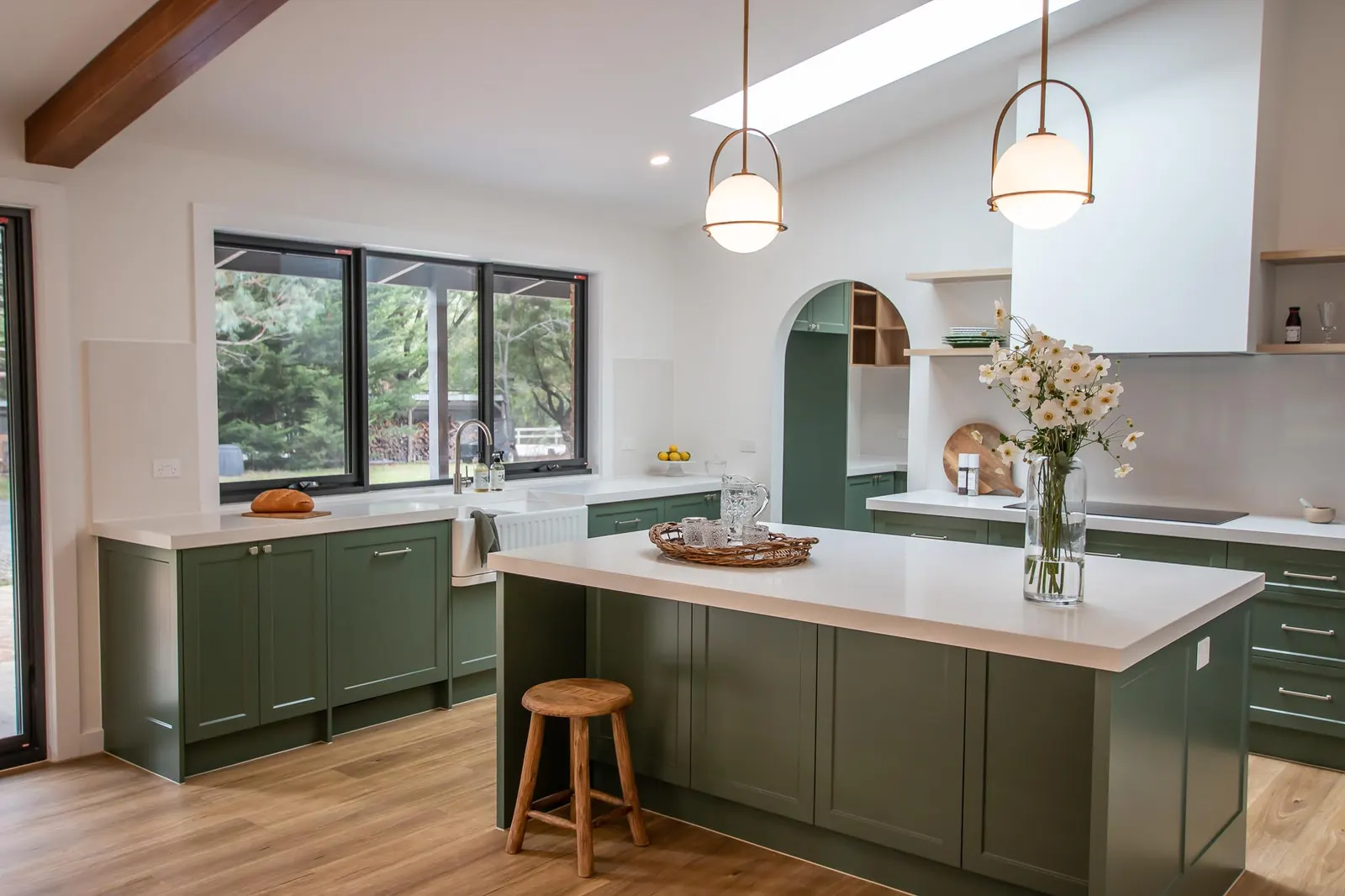 Spencer Rd kitchen with a raked ceiling, exposed beam, pendants and a green island