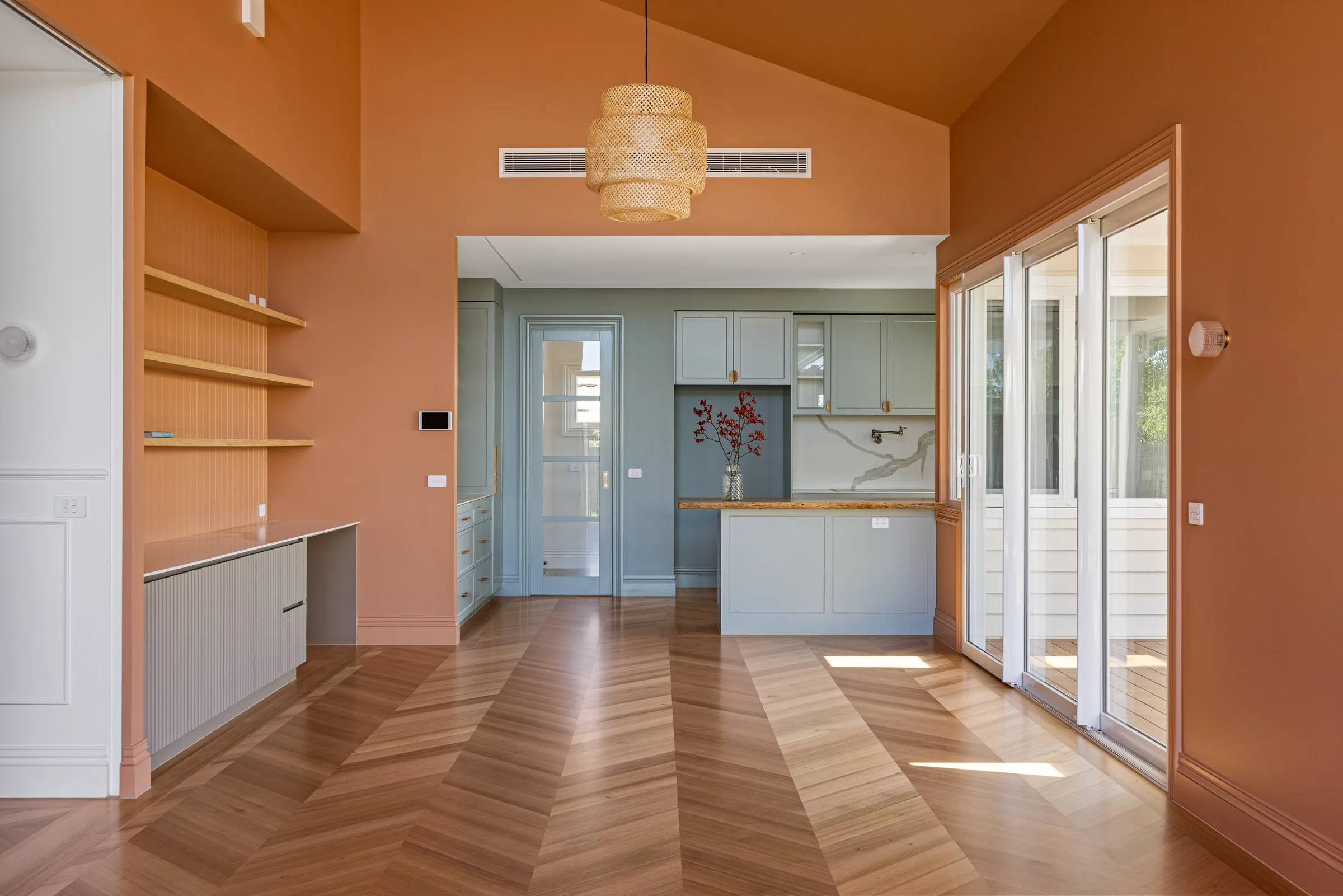 Warren St living and dining under a raked terracotta ceiling, chevron parquet running through to a sage kitchen
