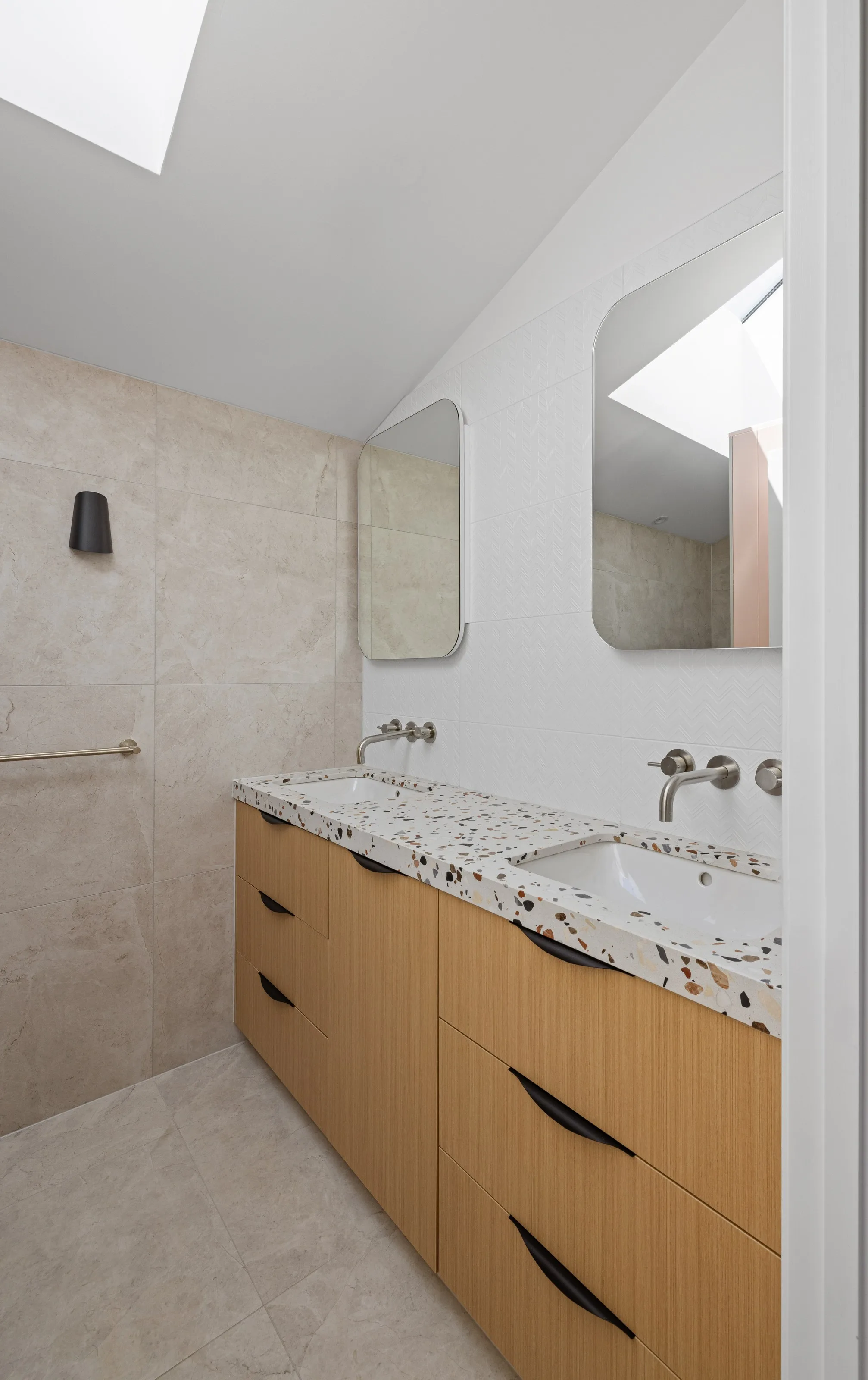 Ensuite double vanity in timber with a terrazzo top, twin mirrors and a skylight above