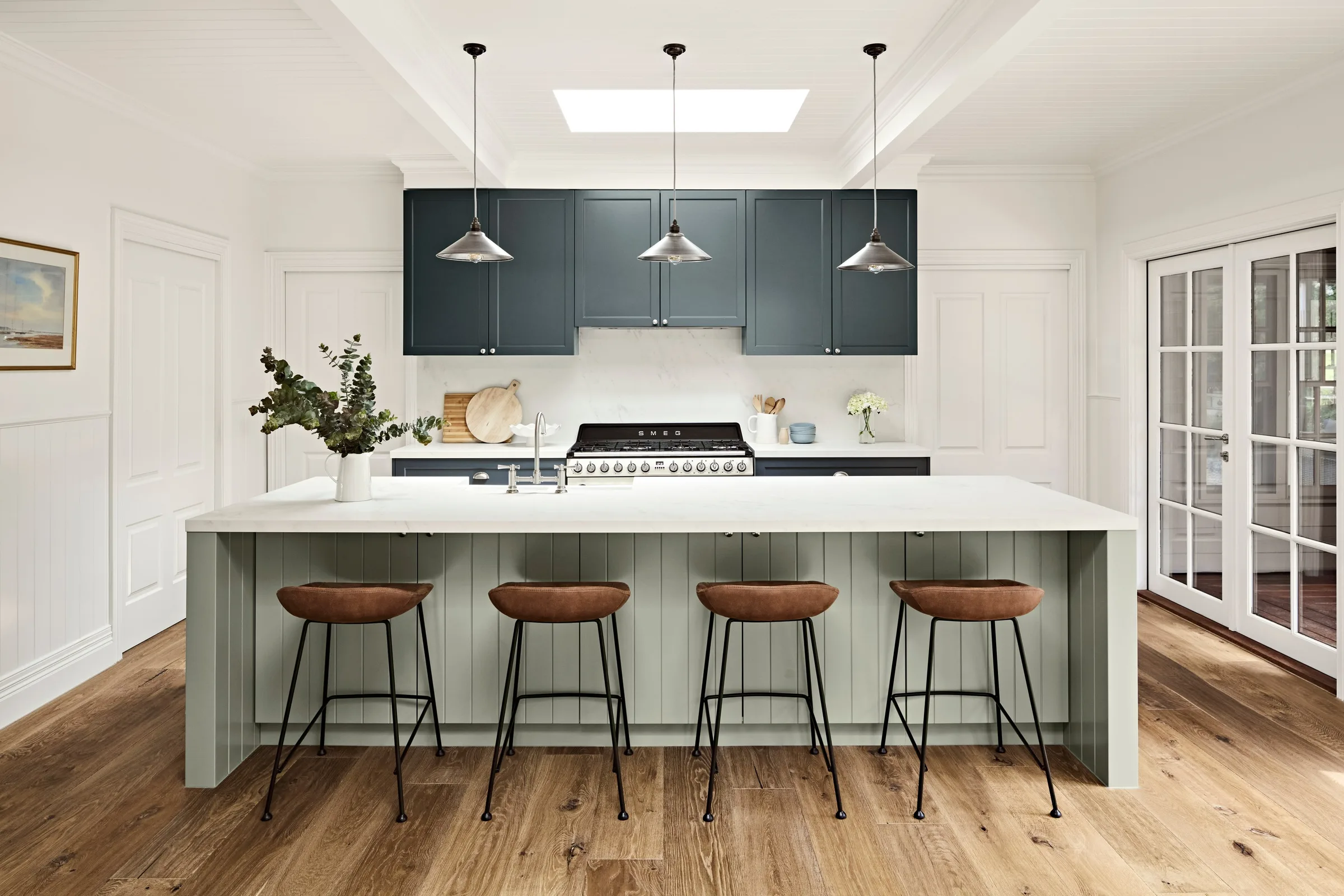 Waterfalls Rd kitchen, pale green island and tan leather stools under three pendants