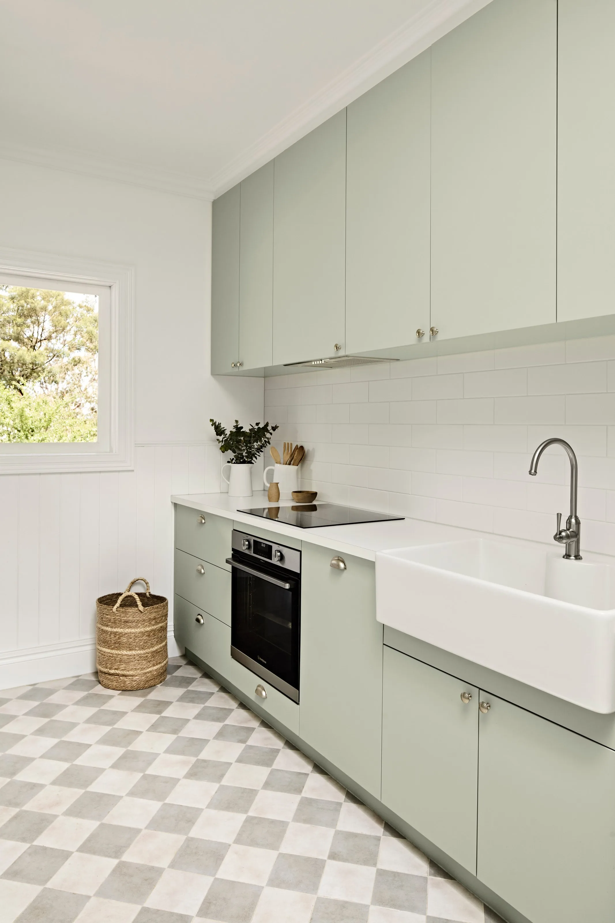 Mint green joinery with butler sink, wall oven and checkerboard floor tiles