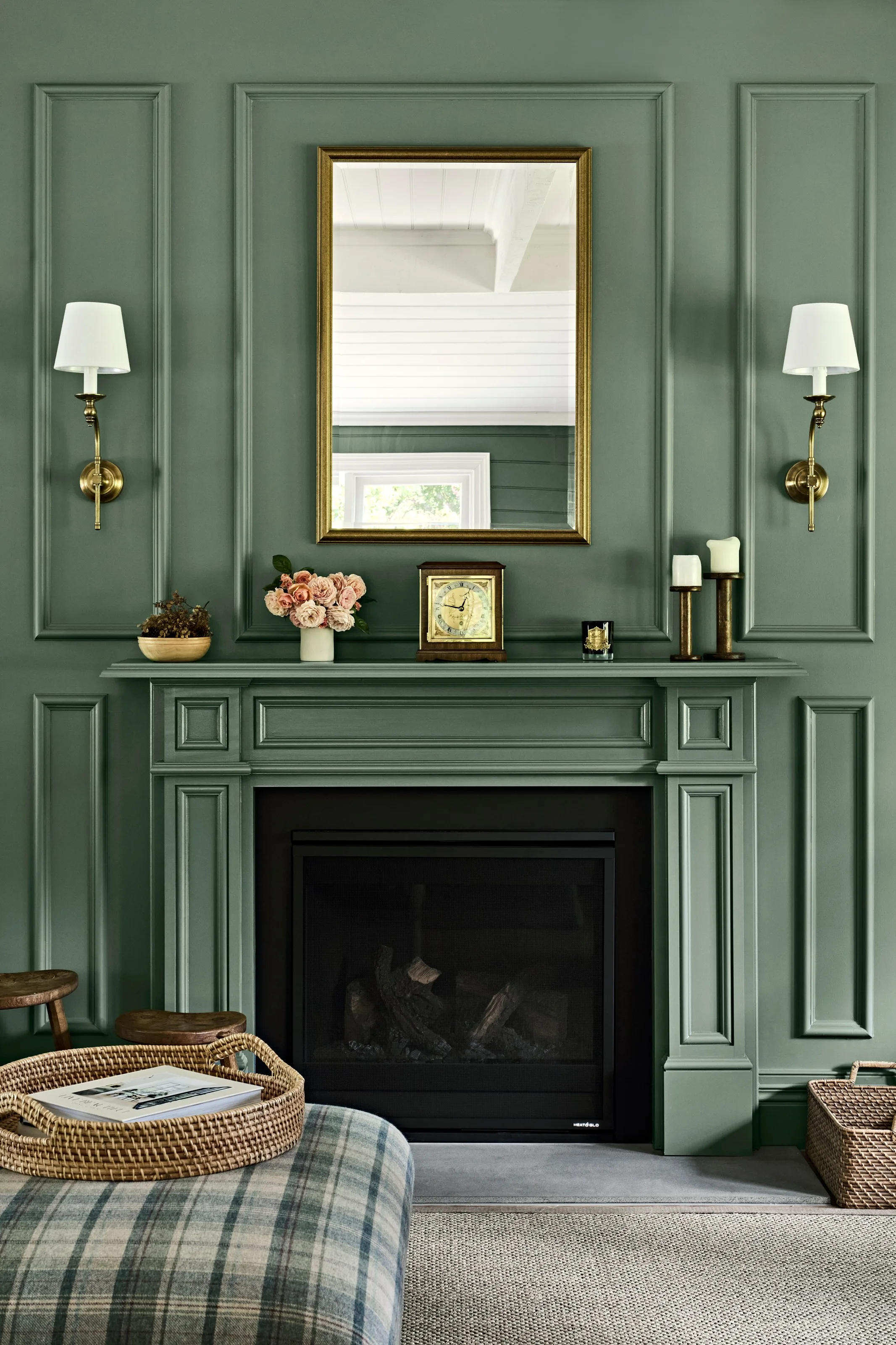 Panelled green chimney breast with gilt mirror and sconces above the mantel