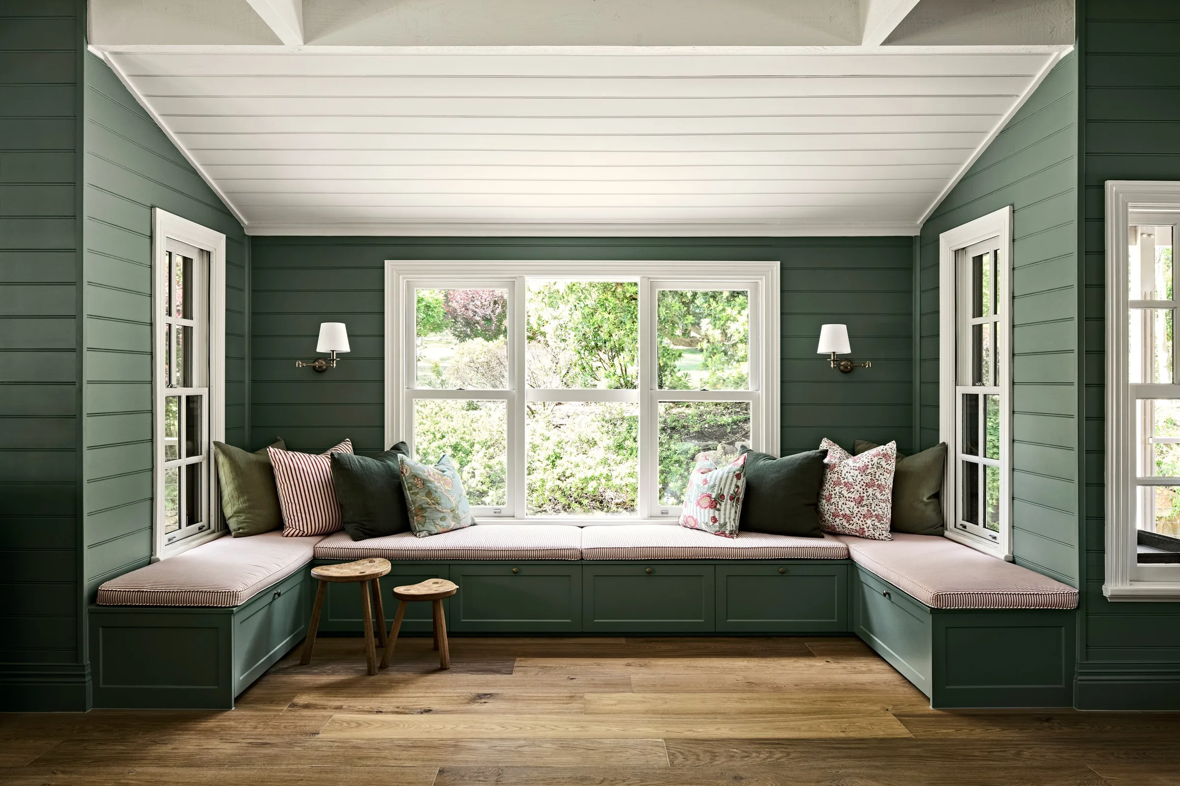 Bench seating wrapping a bay window, timber stools on wide oak boards