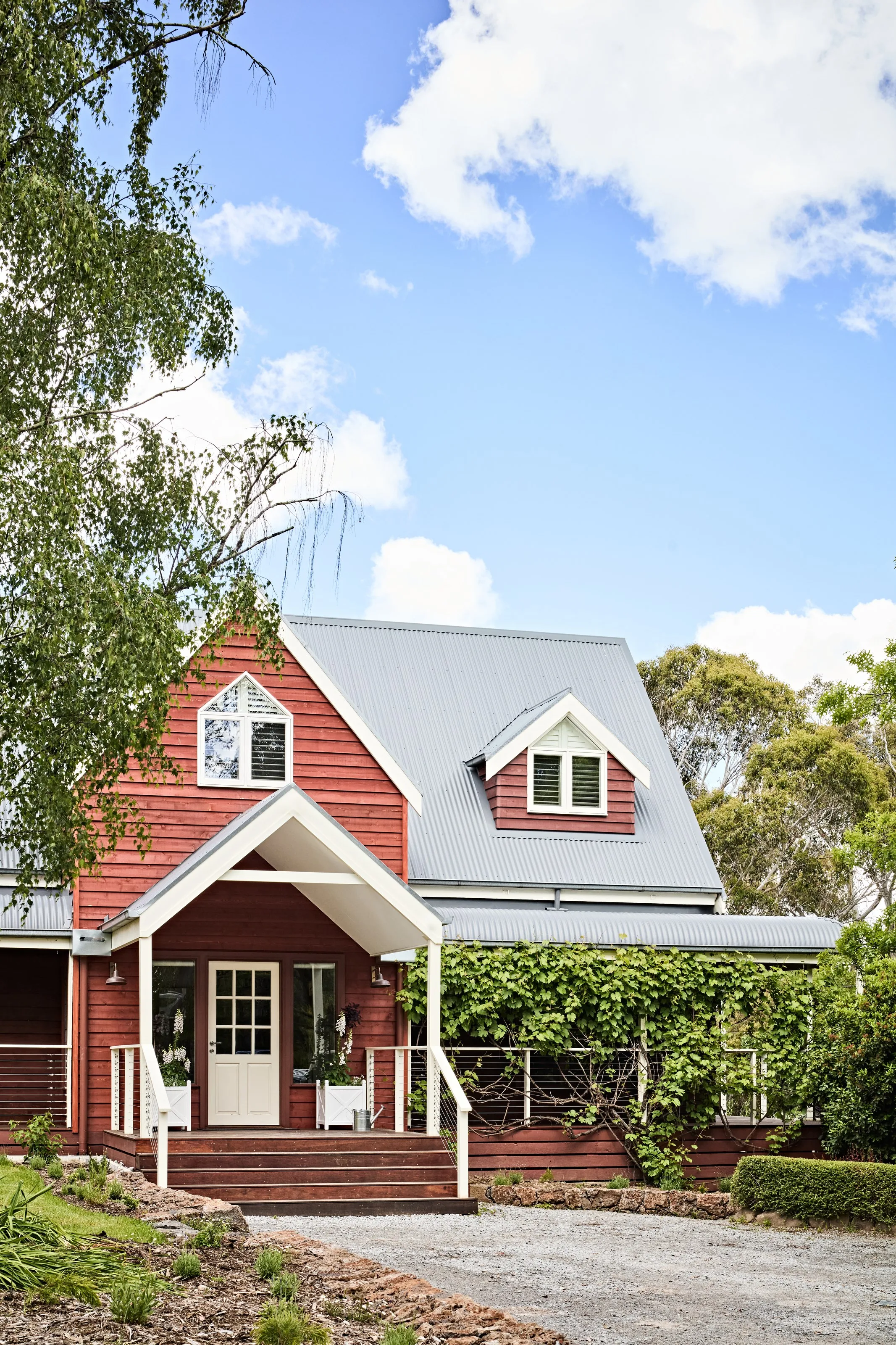 Red weatherboard facade with gabled porch and steel roof &mdash; Waterfalls Rd by Summerfield Homes
