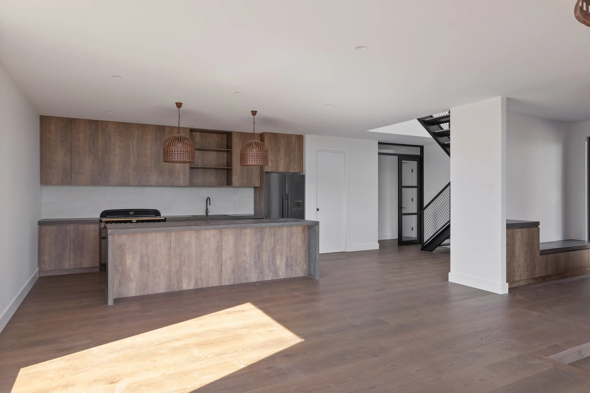 Open plan living looking through to the kitchen island and the black steel stair