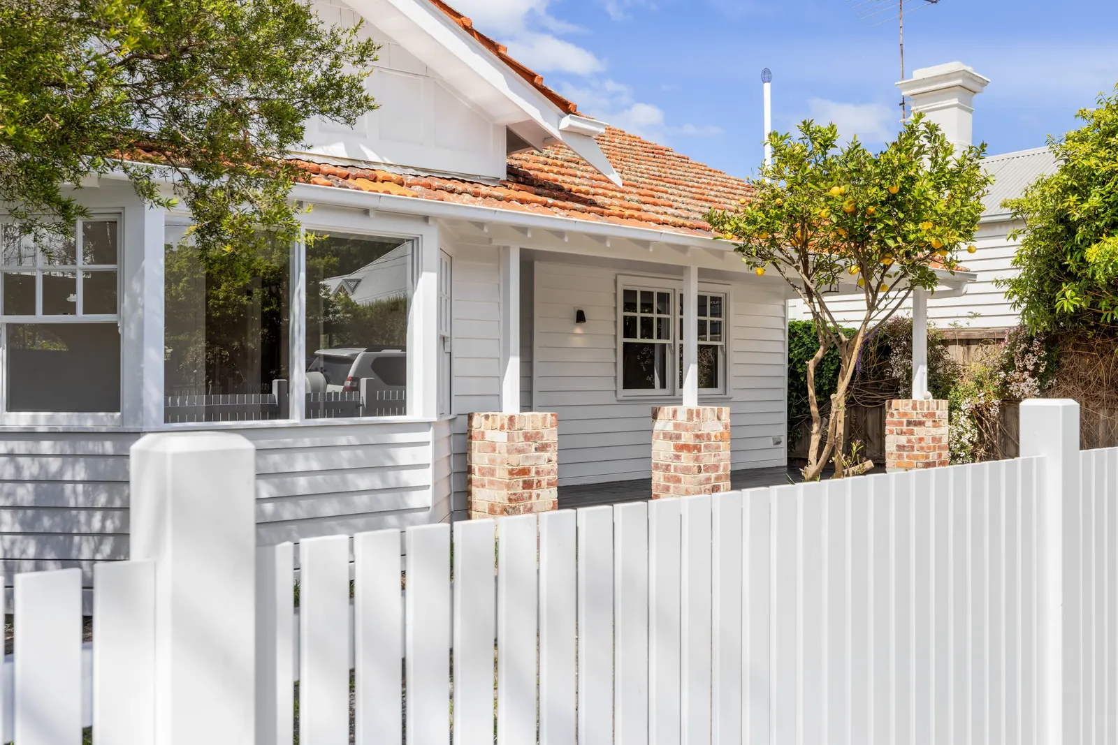 Weatherboard frontage with a picket fence and brick veranda piers, Charles St Williamstown
